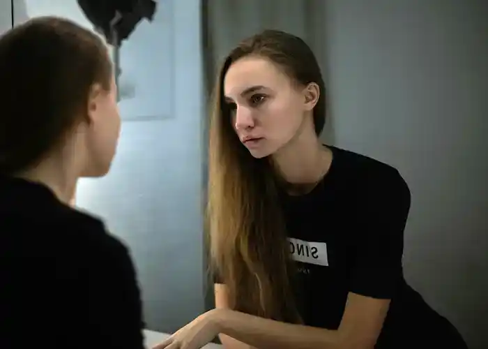 Young girl looking in the mirror